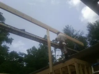 Carpenter setting a ridge beam over a new addition frame — Ice Dam Removal by Roofing Brothers in Mountlake Terrace