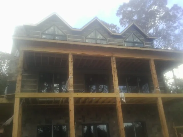 Dormers and porch framing on a large log home under construction — Roof Coating work by our crew in Mountlake Terrace